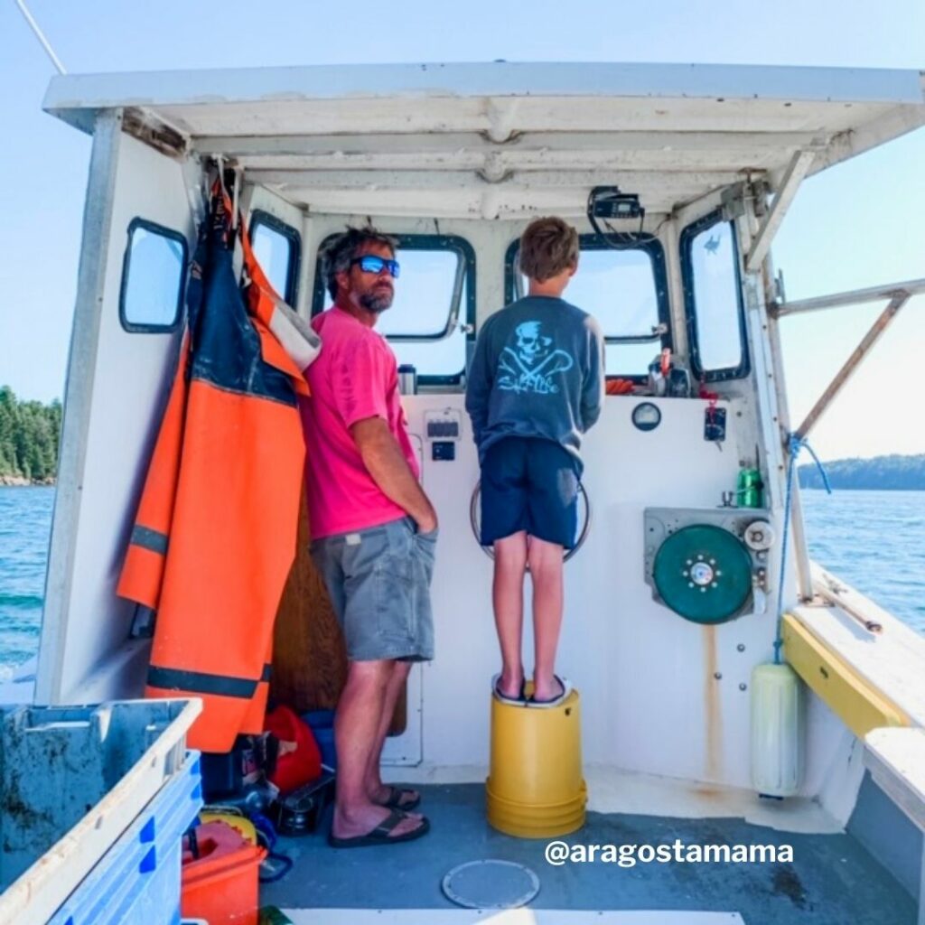 Riley Coombs standing on a bucket with his father while fishing on a boat.